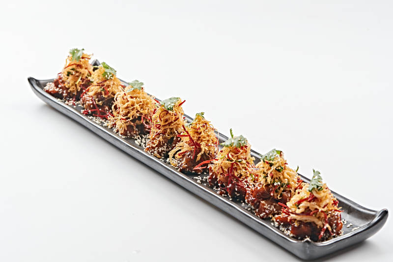 黑色长石盘装的油炸酸菜猪月牙骨图片