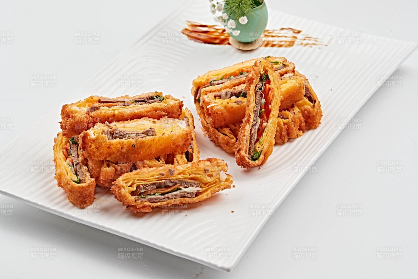 白色瓷盘装的蛋饼香炸小驴肉图片