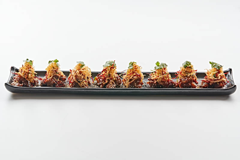 黑色长石盘装的油炸酸菜猪月牙骨图片