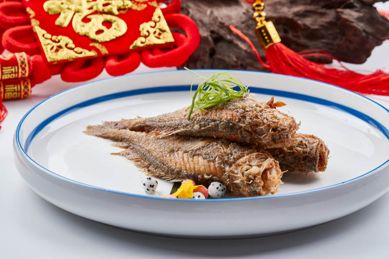 白色瓷盘装的油炸新鲜小黄鱼图片