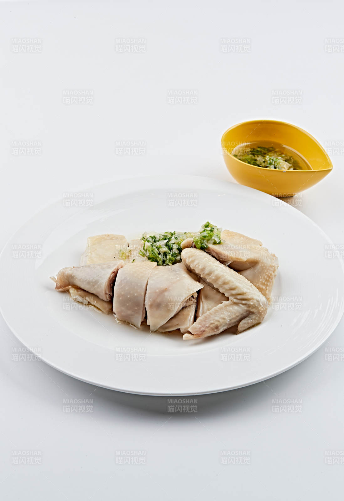 白色盘装的广式蘸汁白切鸡图片