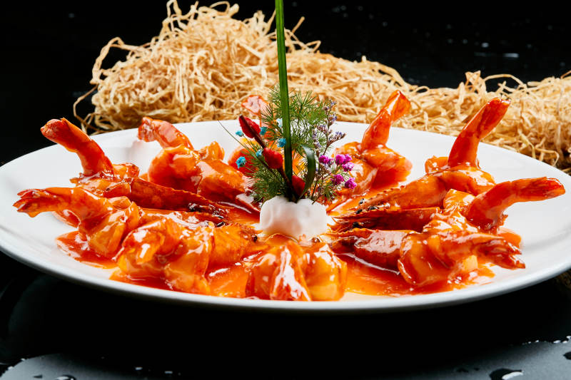 白色瓷盘装的浇汁油炸开背大明虾图片