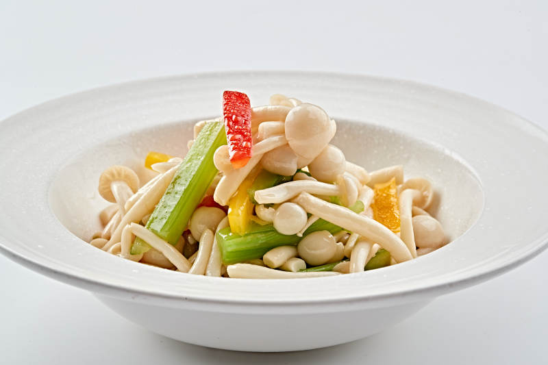 白色瓷盘装的西芹彩椒小炒白玉菇图片