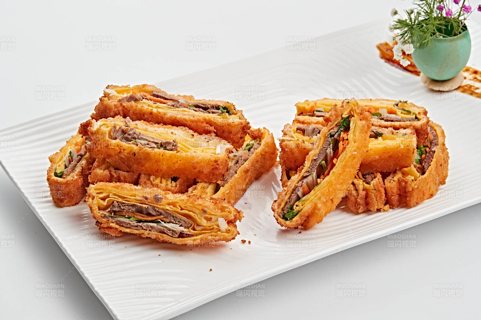 白色瓷盘装的蛋饼香炸小驴肉图片