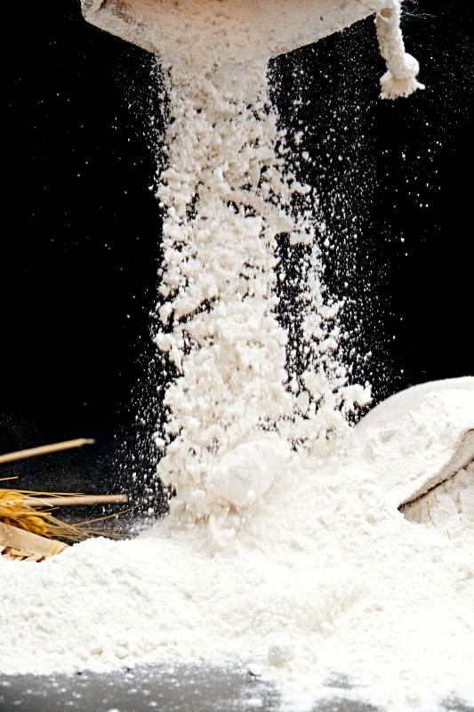 黑色背景上的粗粮荞麦面粉图片