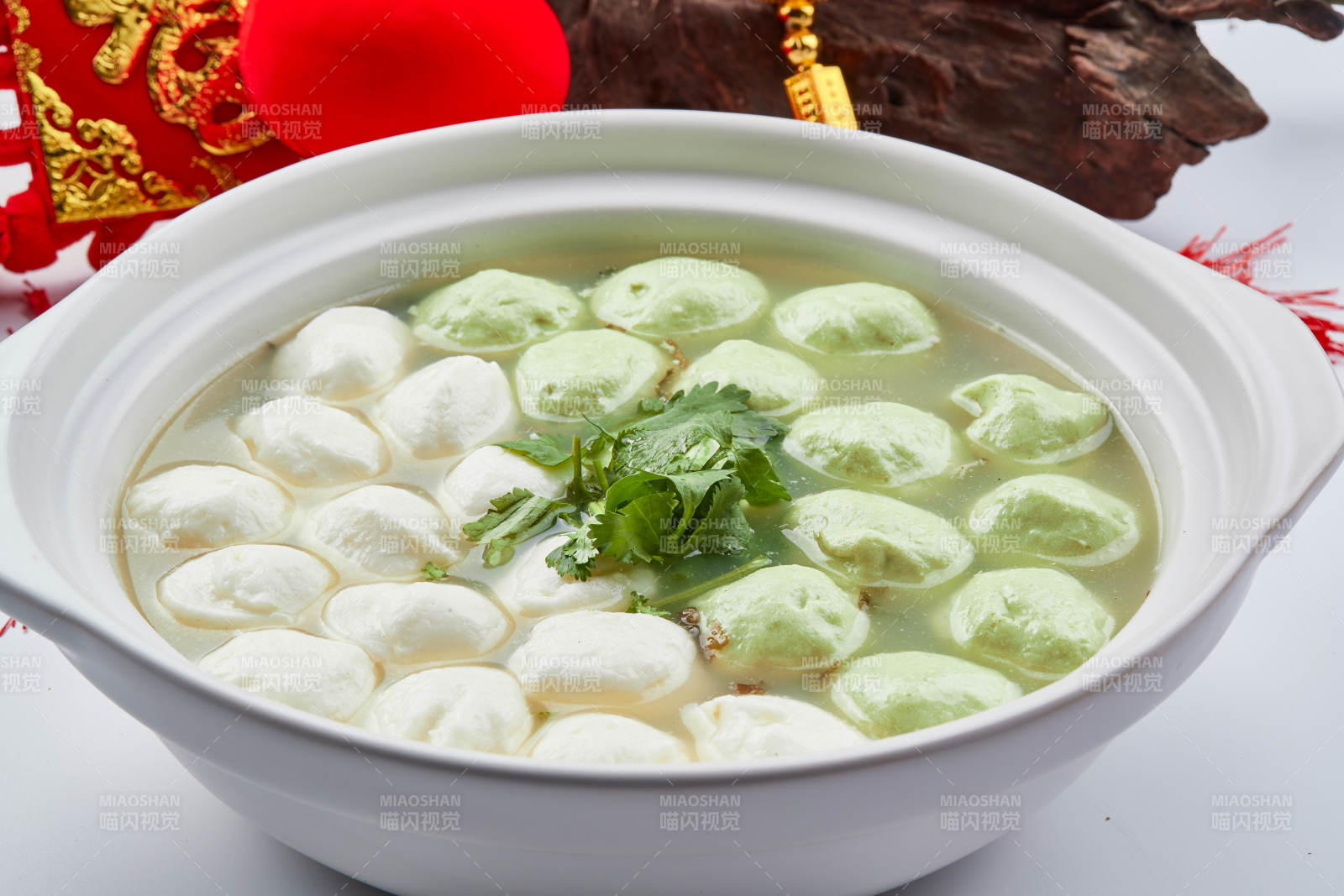 白色砂锅装的双色手打鱼丸图片