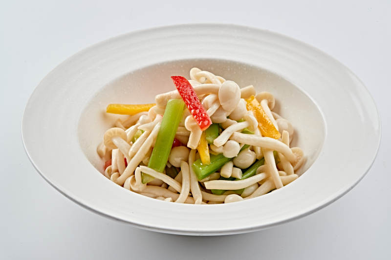 白色瓷盘装的西芹彩椒小炒白玉菇图片