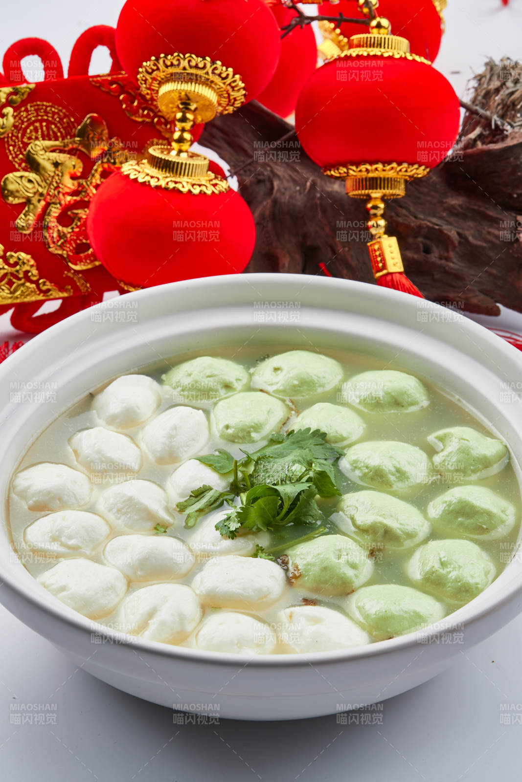 白色砂锅装的双色手打鱼丸图片