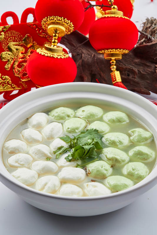 白色砂锅装的双色手打鱼丸图片