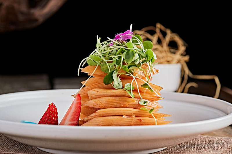 白色瓷盘装的红油香辣萝卜片图片