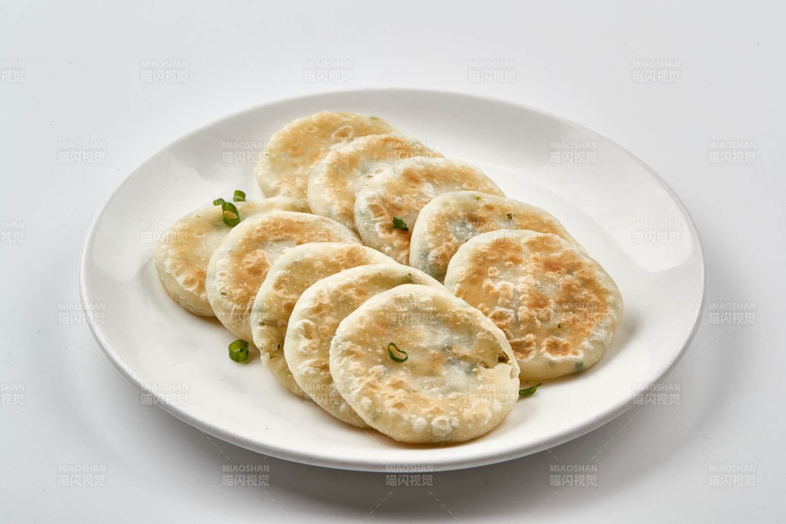 白色瓷盘装的现烙葱油饼图片