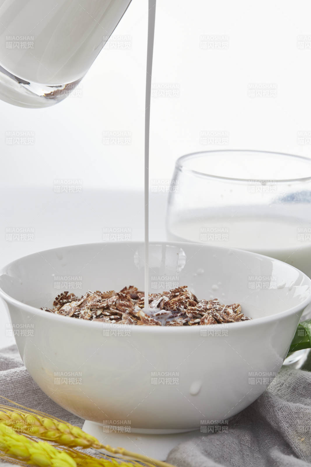 向装满低脂黑燕麦片的碗中倾倒牛奶图片