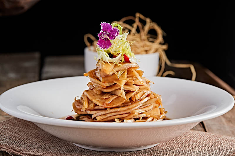 白色瓷盘装的醋腌萝卜皮图片