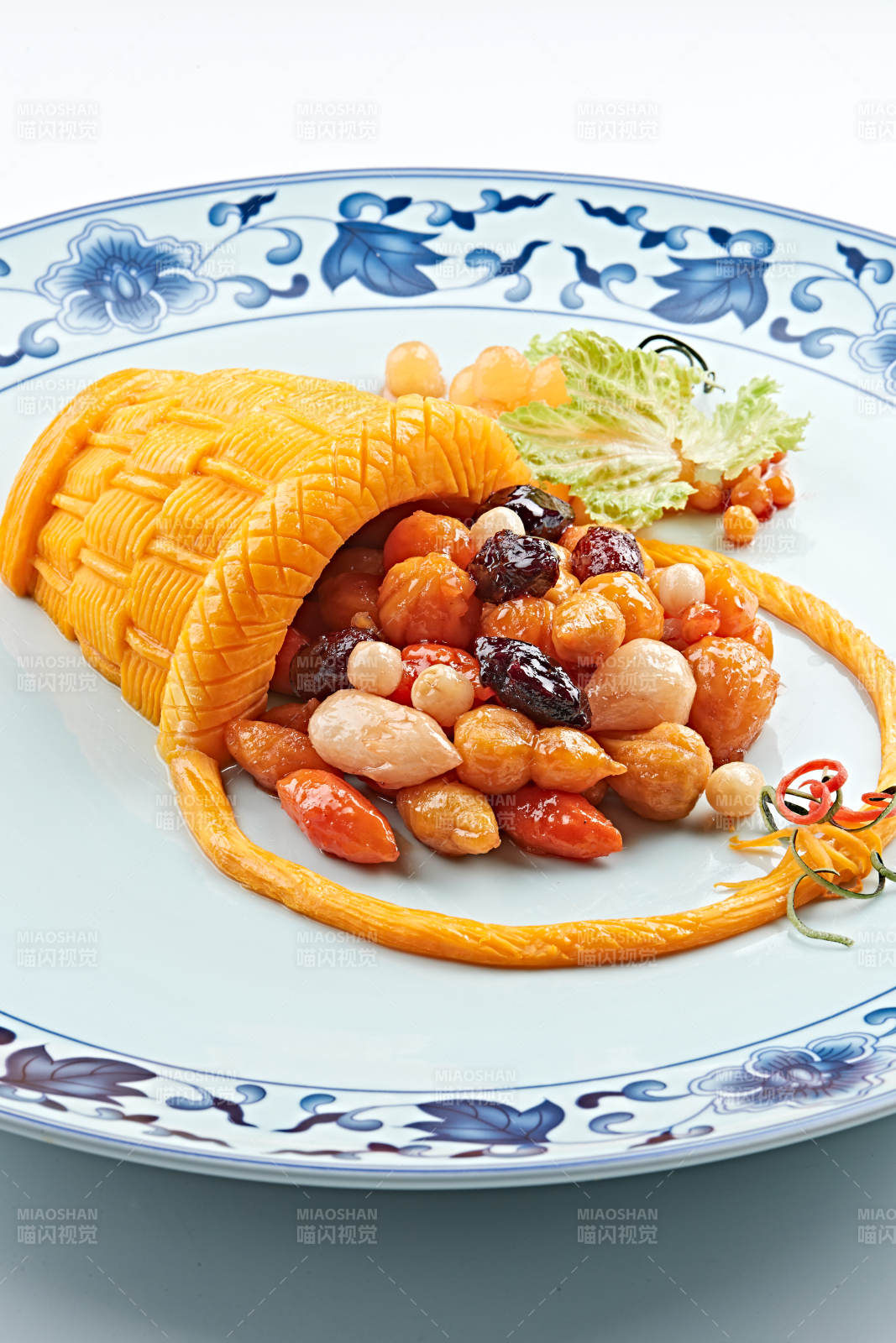 青花瓷盘装的精美雕刻摆盘的富贵花篮图片