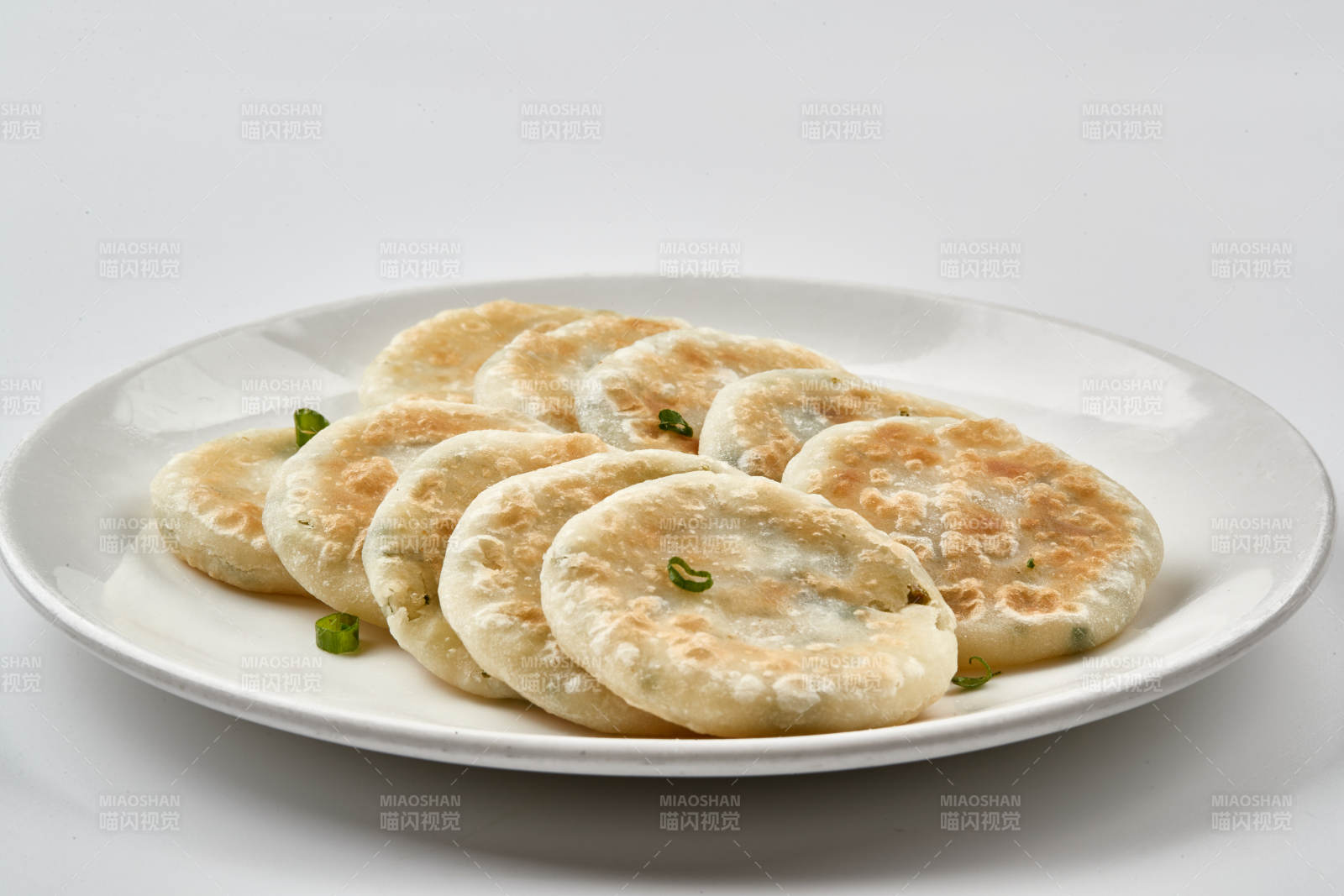 白色瓷盘装的现烙葱油饼图片