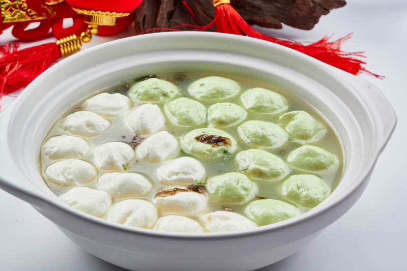 白色砂锅装的双色手打鱼丸图片