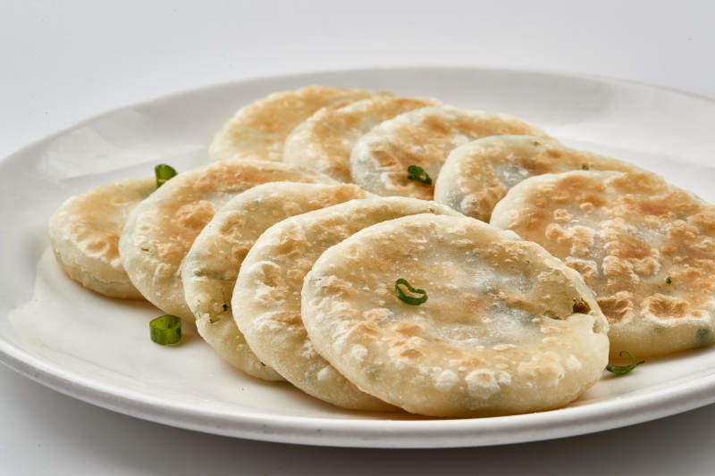 白色瓷盘装的现烙葱油饼图片