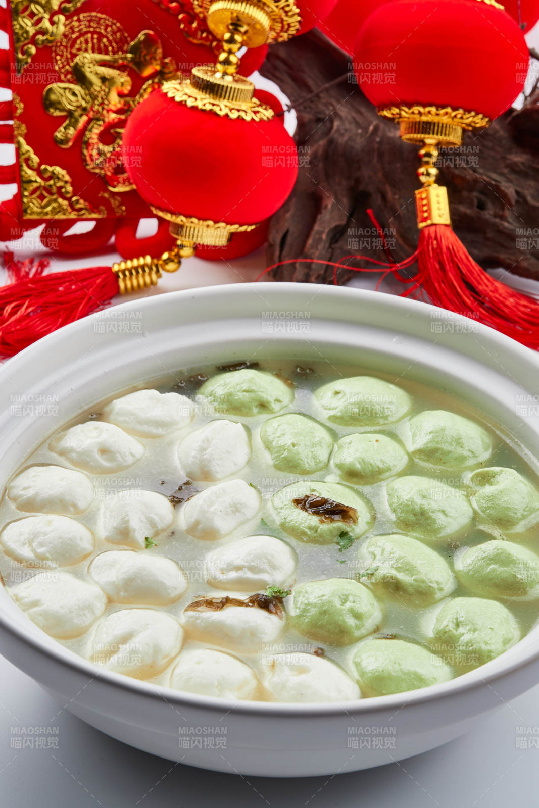 白色砂锅装的双色手打鱼丸图片