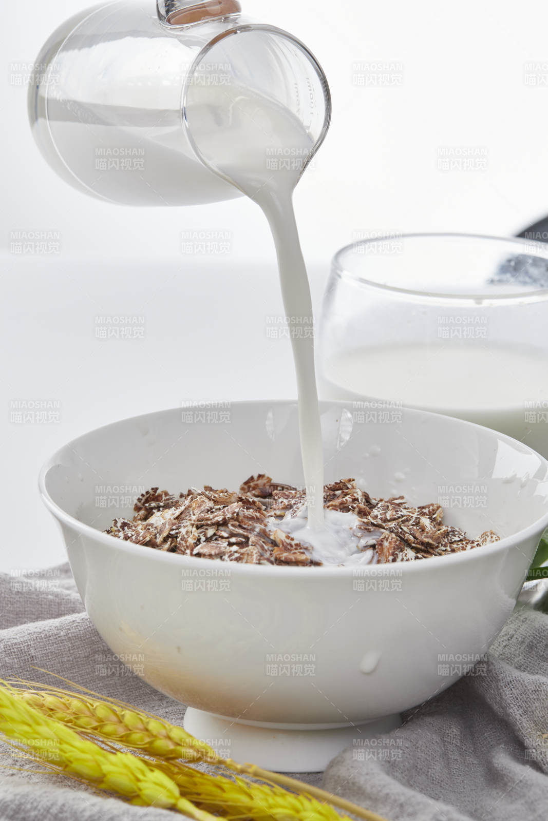 向装满低脂黑燕麦片的碗中倾倒牛奶图片