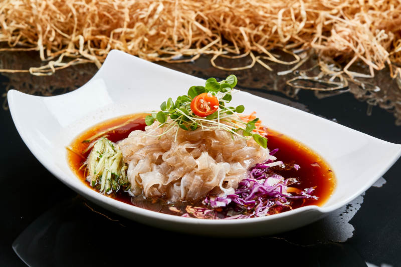 白色瓷盘装的浇汁时蔬山药大拉皮图片