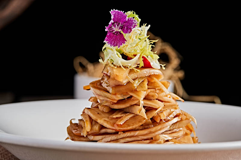 白色瓷盘装的醋腌萝卜皮图片