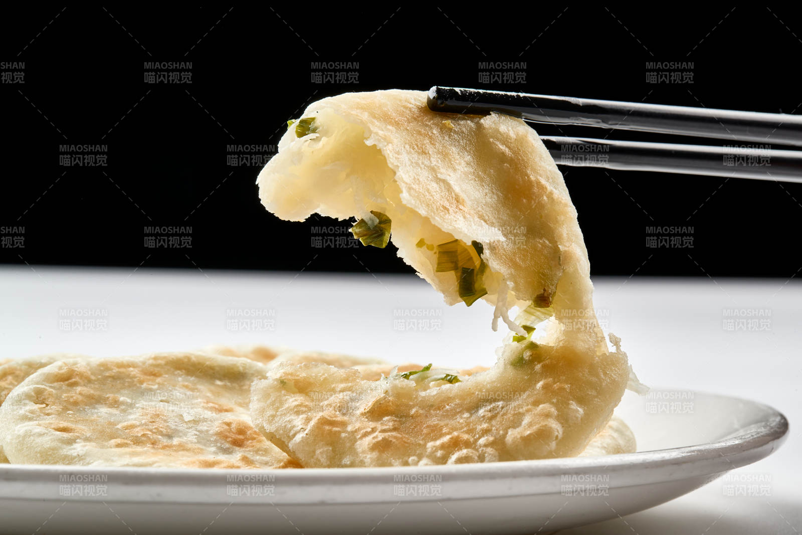 白色瓷盘装的现烙葱油饼图片