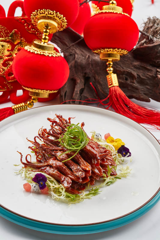 白色瓷盘装的美味卤鸭舌图片