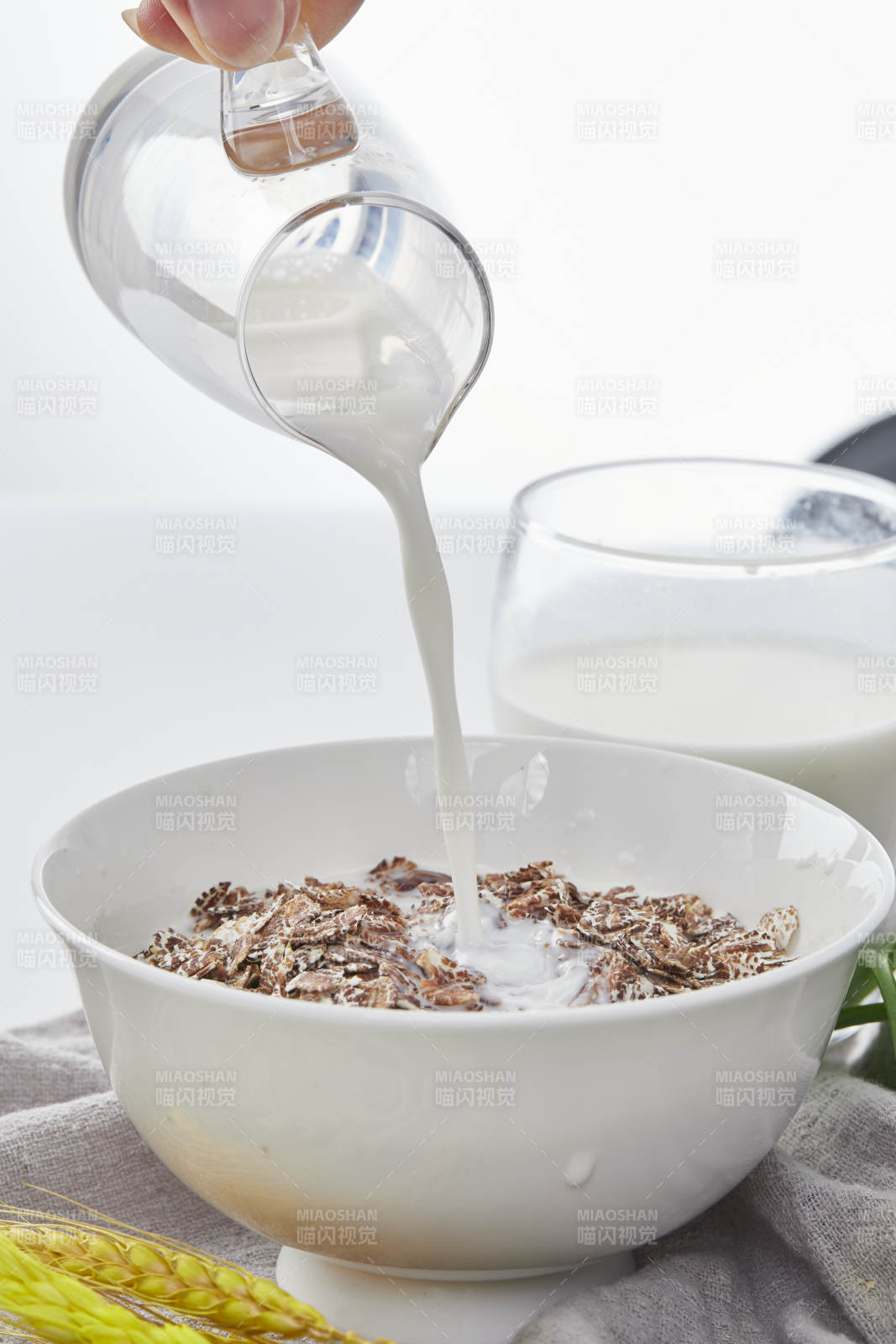 向装满低脂黑燕麦片的碗中倾倒牛奶图片