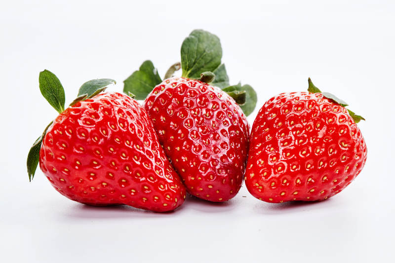 白色背景上摆放的新鲜草莓图片