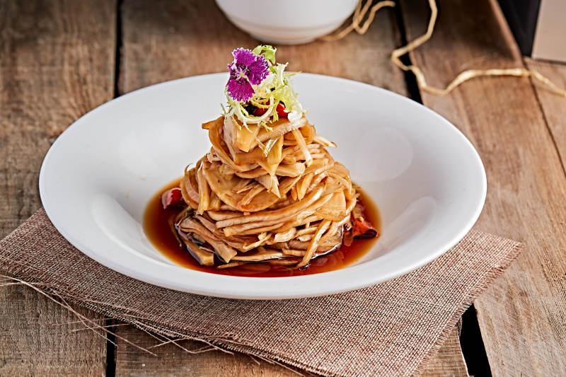 白色瓷盘装的醋腌萝卜皮图片