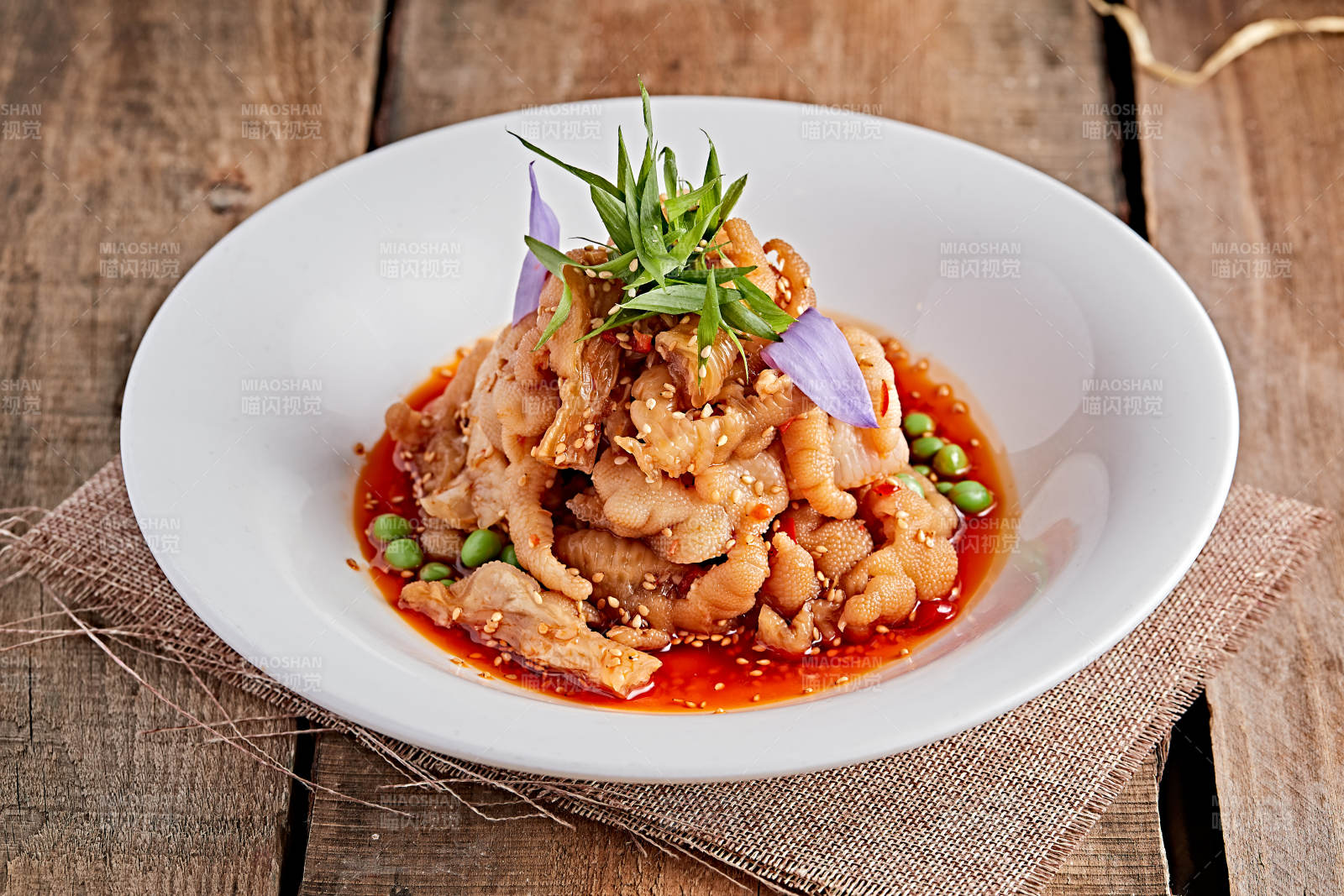 白色瓷盘装的红油酸辣脱骨凤爪图片