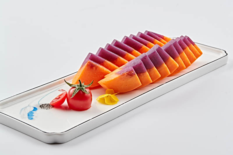 白色长瓷盘装的凉菜紫薯木瓜图片