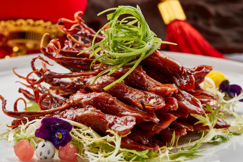 白色瓷盘装的美味卤鸭舌图片