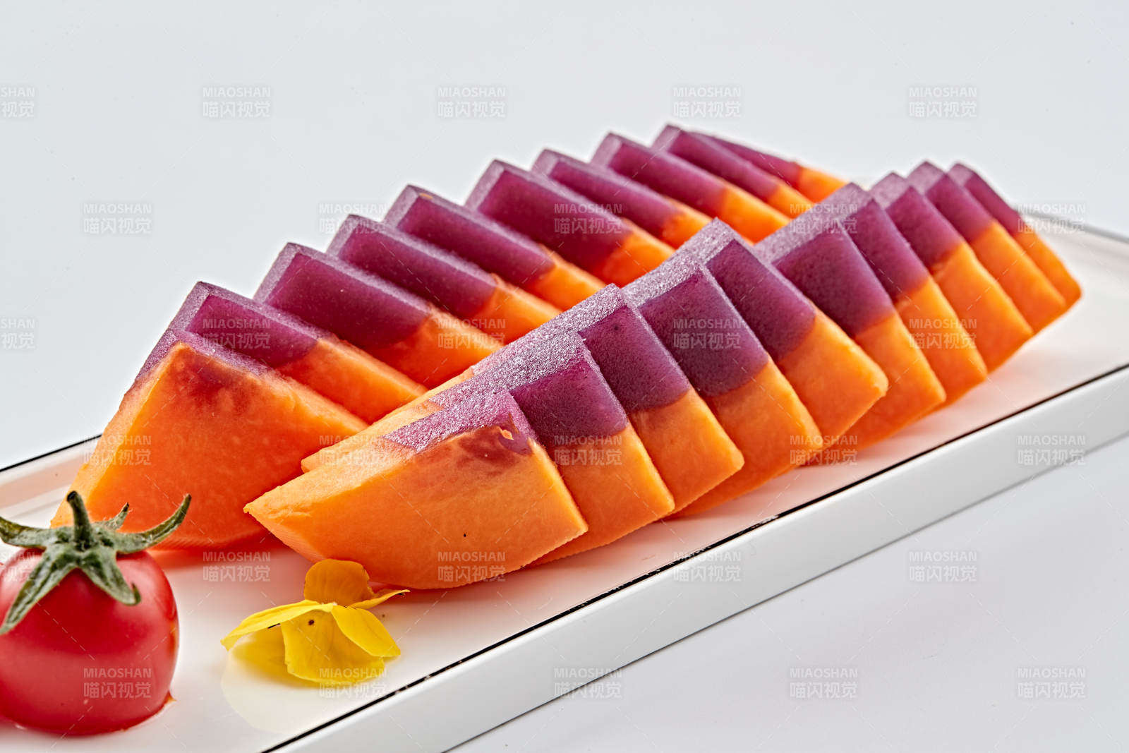 白色长瓷盘装的凉菜紫薯木瓜图片