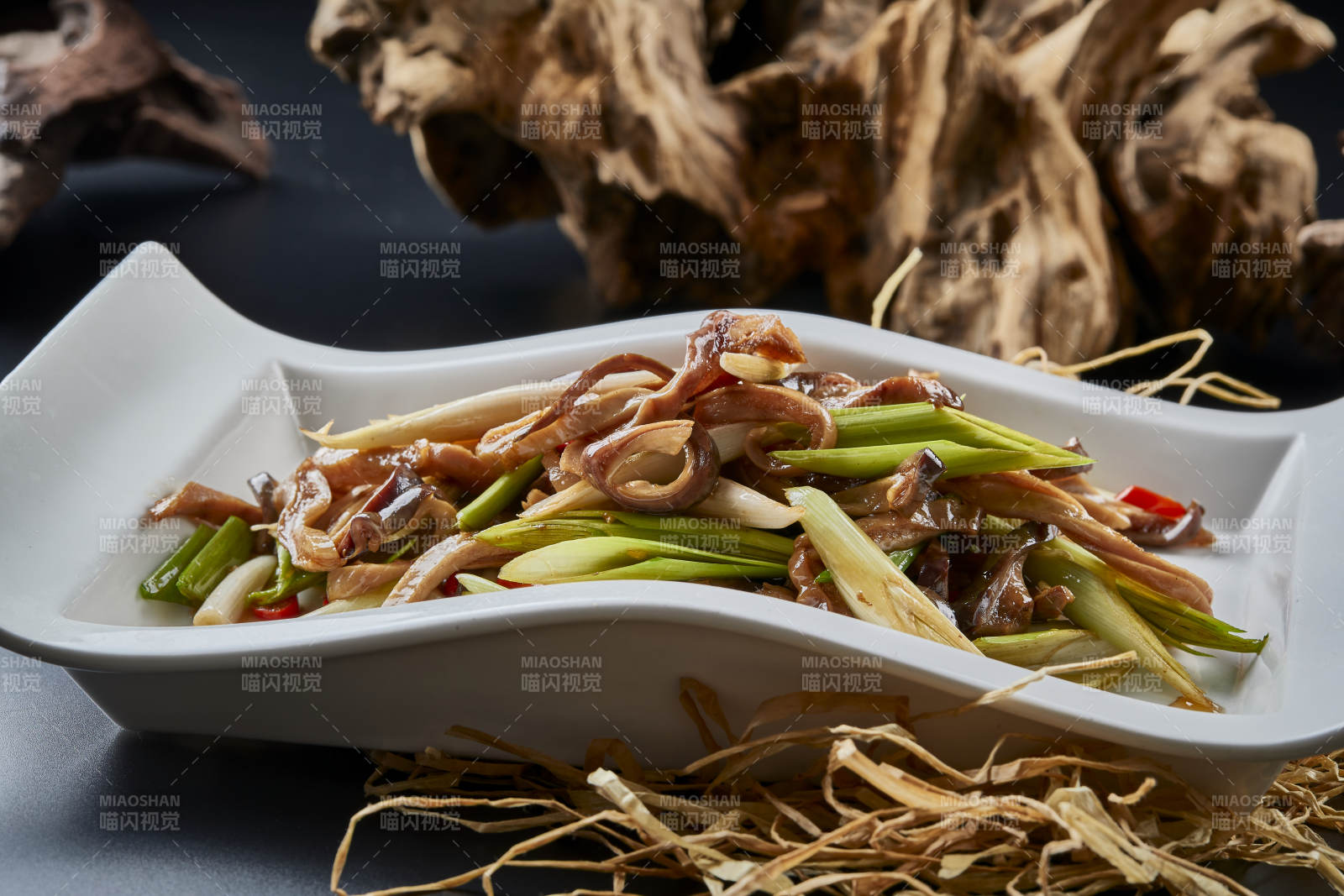 白瓷盘装的香辣青蒜炒猪肚丝图片