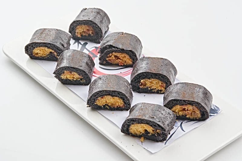 白色瓷盘装的紫米面小米杂粮卷图片