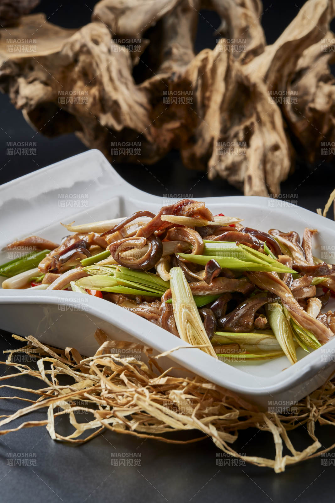 白瓷盘装的香辣青蒜炒猪肚丝图片