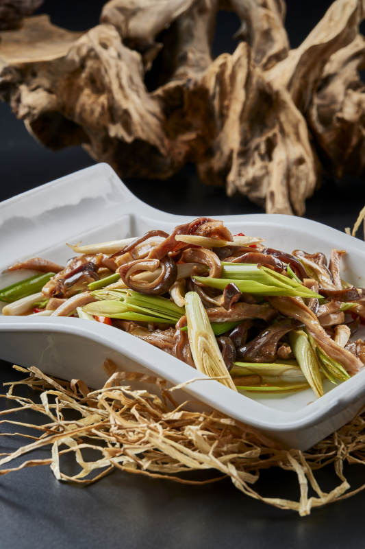 白瓷盘装的香辣青蒜炒猪肚丝图片