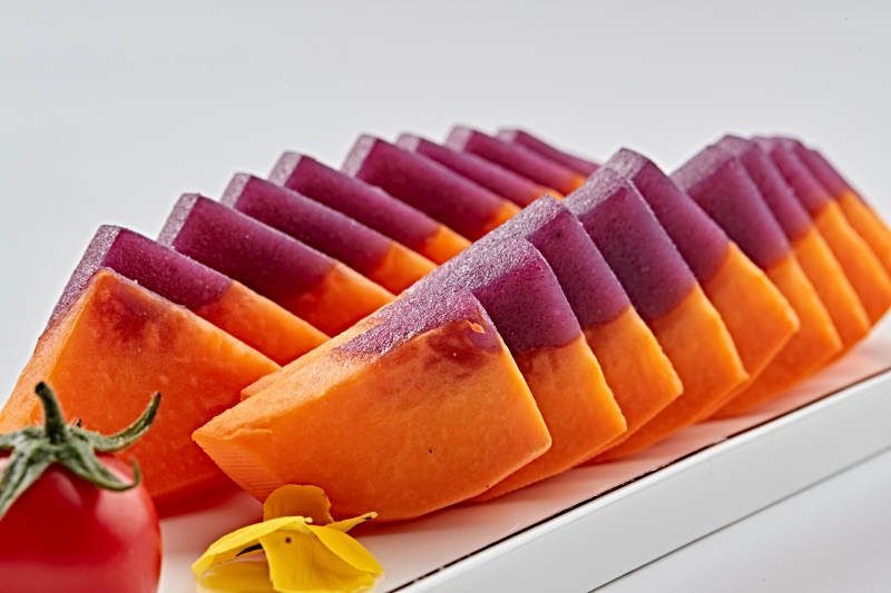 白色长瓷盘装的凉菜紫薯木瓜图片