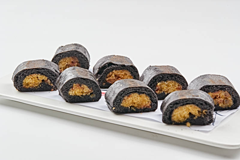 白色瓷盘装的紫米面小米杂粮卷图片