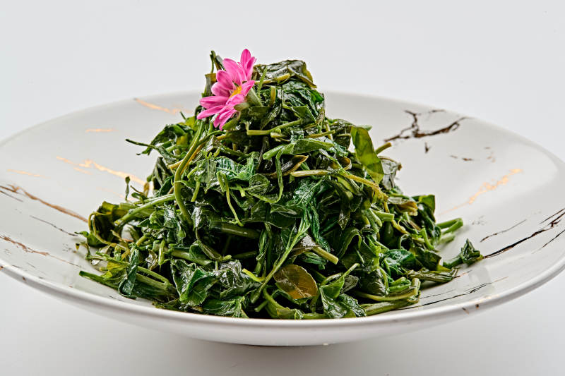 白色瓷盘装的凉拌丝瓜苗图片