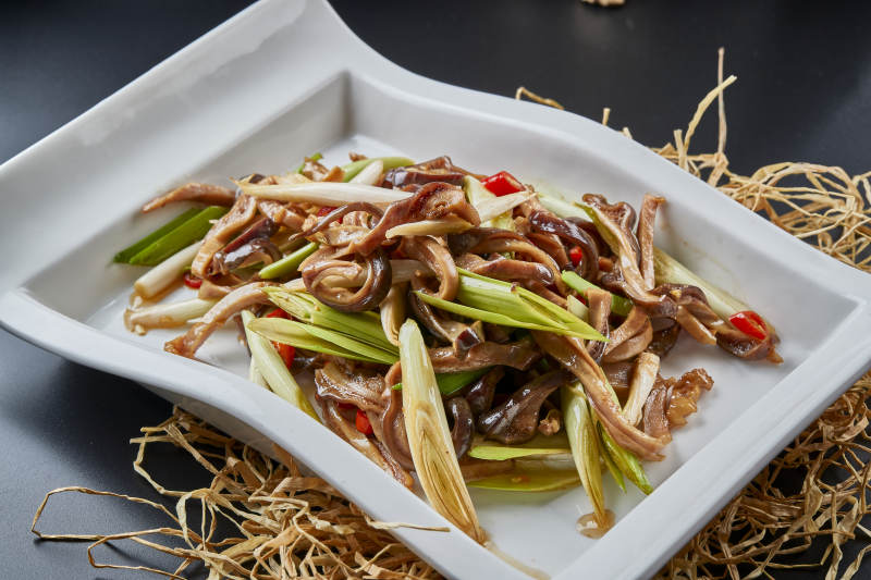 白瓷盘装的香辣青蒜炒猪肚丝图片
