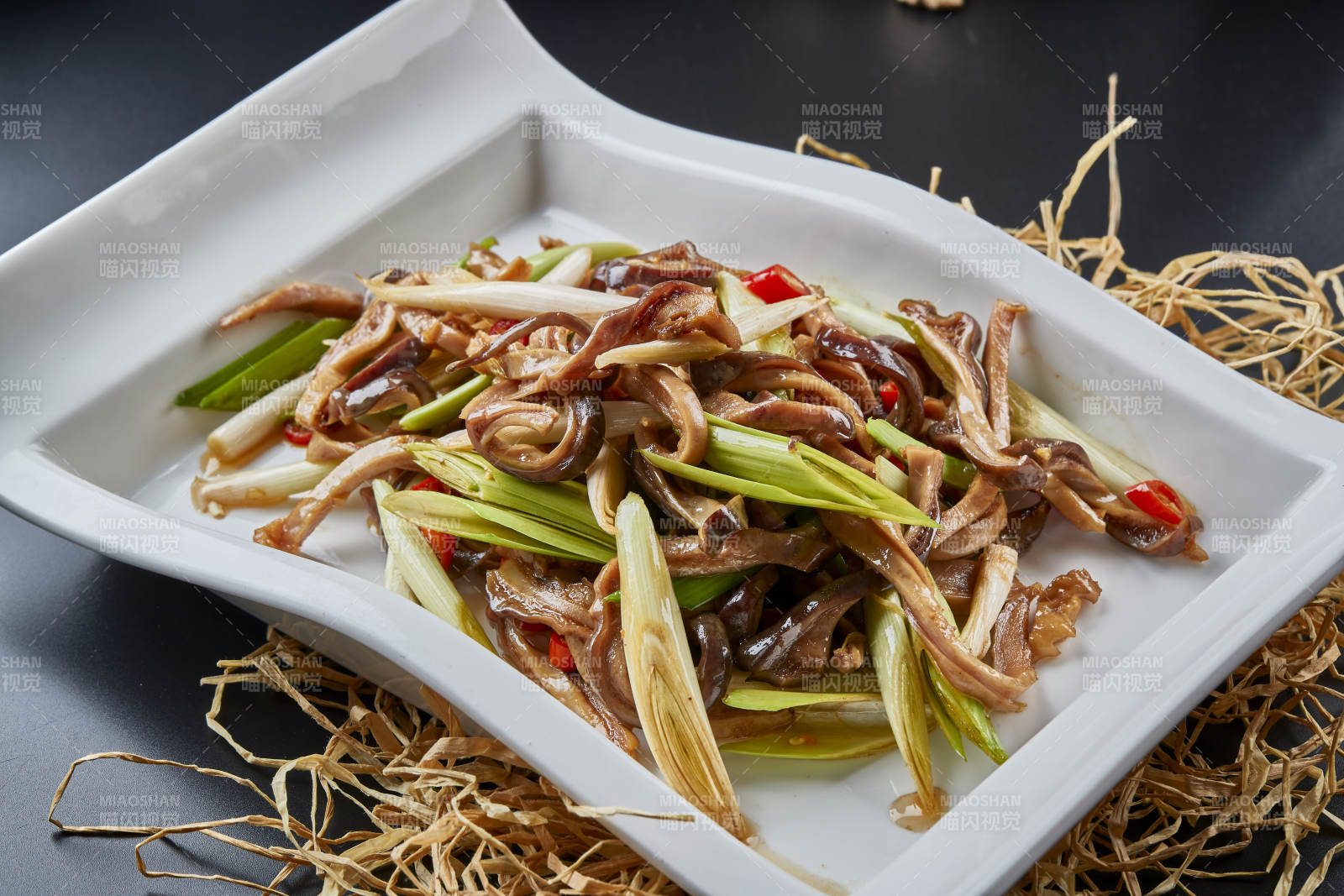 白瓷盘装的香辣青蒜炒猪肚丝图片