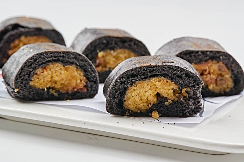 白色瓷盘装的紫米面小米杂粮卷图片