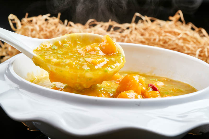 白色瓷餐具装的浓香青豆金米南瓜羹图片