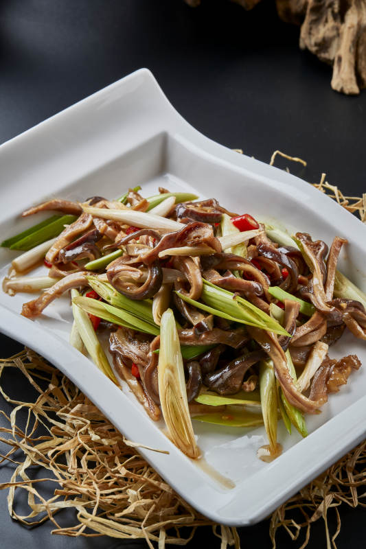 白瓷盘装的香辣青蒜炒猪肚丝图片