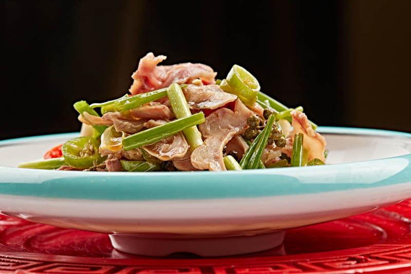 白色瓷盘装的苦菊炝拌茶树菇图片