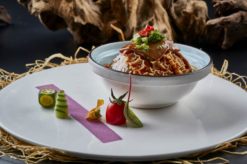 黑色背景上的瓷餐具装的川味夫妻肺片图片