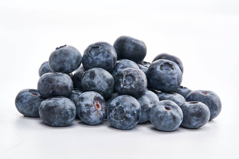 白色背景上摆放的水润新鲜蓝莓果图片