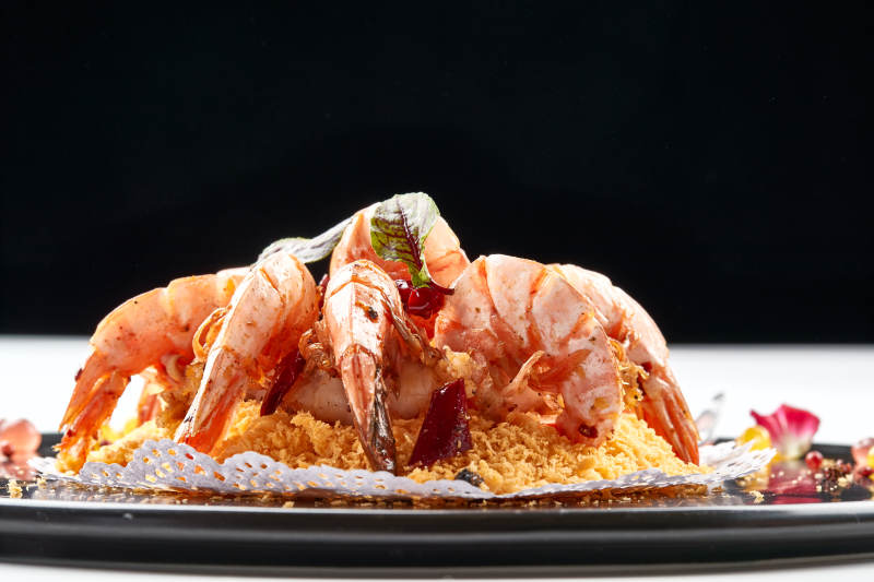 黑色瓷盘装的避风塘炸虾图片